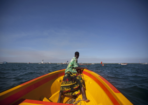 Man watching the dhow race from prow of observation boat, Lamu County, Lamu, Kenya