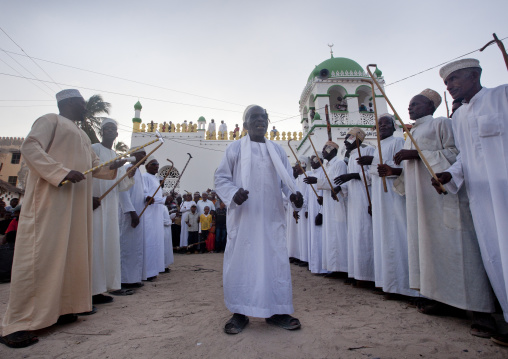 Muslim men singing and dancing with goma sticks during Maulid festival, Lamu County, Lamu, Kenya