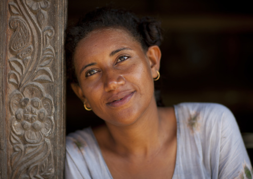 Kenyan woman leaning on a wooden carved pillar, Lamu County, Lamu, Kenya