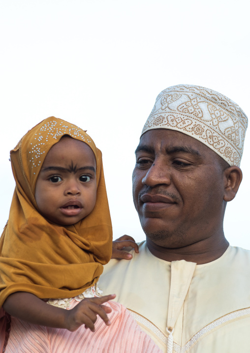 Sunni muslim father and daughter celebrating the maulidi festivities in the street, Lamu county, Lamu town, Kenya