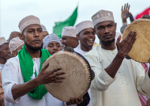 Sunni muslim men playing tambourines during the maulidi festivities in the street, Lamu county, Lamu town, Kenya