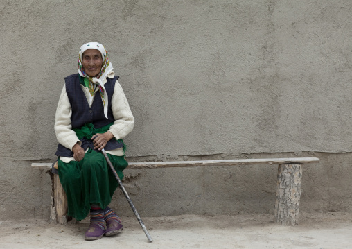 Old Veiled Woman Sitting On A Bench In Kochkor, Kyrgyzstan