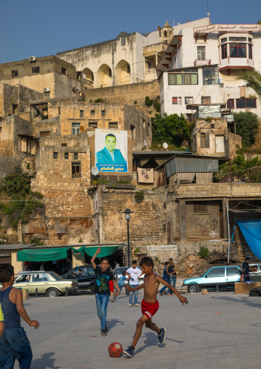 Syrian refugees children playing football in front of residential apartments and housing, North Governorate, Tripoli, Lebanon