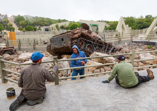 Workers painting fences in the war museum operated by Hezbollah called the tourist landmark of the resistance, South Governorate, Mleeta, Lebanon