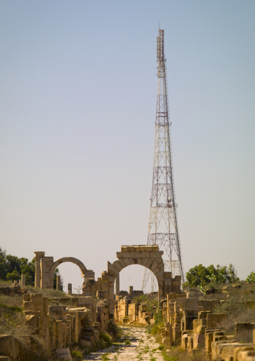 The via trionfale with a telecom antenna in the back in leptis magna, Tripolitania, Khoms, Libya