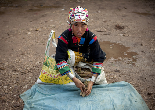 Akha minority woman with traditional headdress in a market, Muang sing, Laos