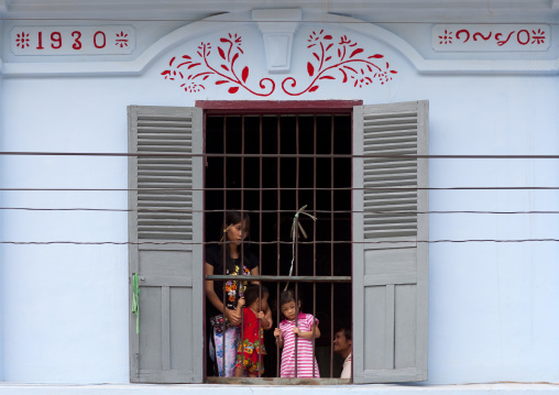 Family looking from a window, Luang prabang, Laos