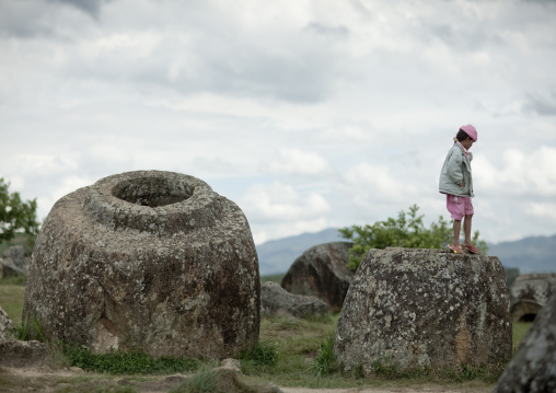 Tourist standing on a jar, Plain of jars, Phonsavan, Laos