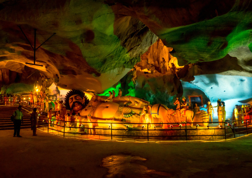 Tourists Looking At Laying Hindu Statue In The Batu Caves, Southeast Asia, Kuala Lumpur, Malaysia