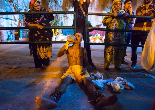 Hindu Devotee In Annual Thaipusam Religious Festival In Batu Caves Drinking Water At The End Of His Pilgrimage, Southeast Asia, Kuala Lumpur, Malaysia