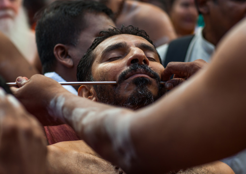 A Devotee Cheek Is Pierced With A Skewer By A Priest At Thaipusam Hindu Festival At Batu Caves, Southeast Asia, Kuala Lumpur, Malaysia