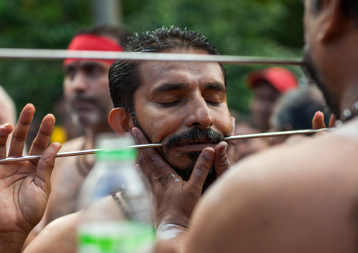 A Devotee Cheek Is Pierced With A Skewer By A Priest At Thaipusam Hindu Festival At Batu Caves, Southeast Asia, Kuala Lumpur, Malaysia