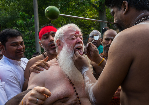 An Australian Hindu Devotee Cheek Is Pierced By A Priest At Thaipusam Hindu Festival At Batu Cave, Southeast Asia, Kuala Lumpur, Malaysia