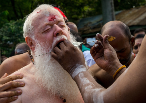 Carl, An Australian Hindu Devotee Cheek Is Pierced By A Priest At Thaipusam Hindu Festival At Batu Cave, Southeast Asia, Kuala Lumpur, Malaysia