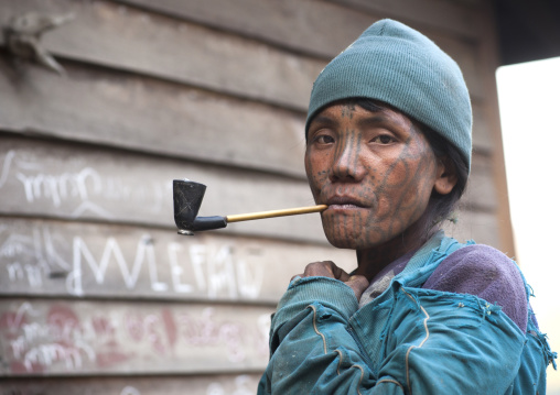 Tribal Chin Woman From Muun Tribe With Tattoo On The Face Smoking, Mindat, Myanmar