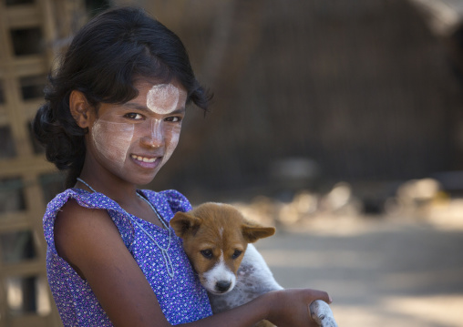 Girl With Thanaka On Cheeks Carrying A Dog, Ngapali, Myanmar