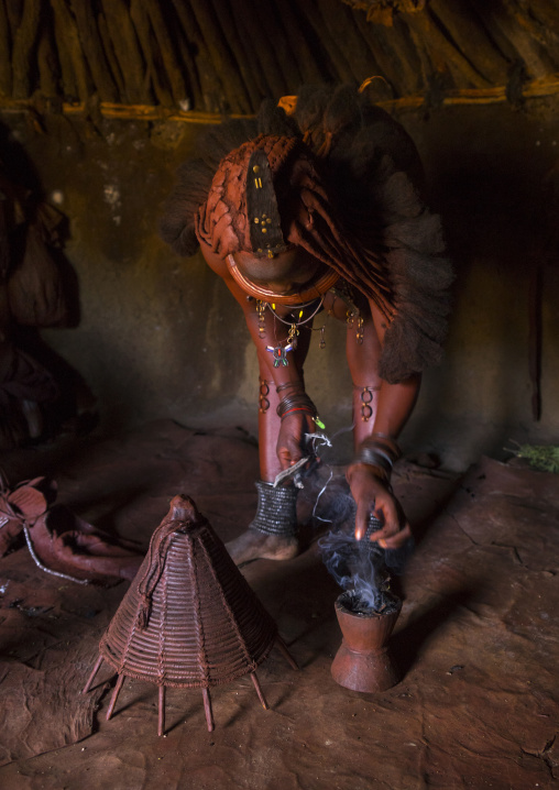 Himba Woman Using Incense To Purify Herself And Her Clothes, Epupa, Namibia