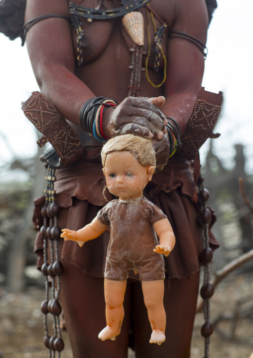 Himba Woman Washing A Blonde Doll, Epupa, Namibia