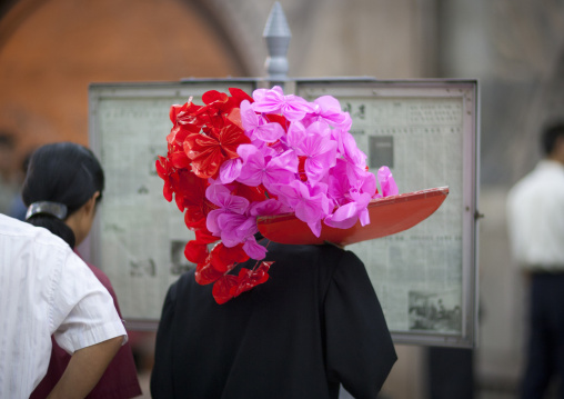 North Korean man with flower after a parade reading a newspaper in the subway, Pyongan Province, Pyongyang, North Korea