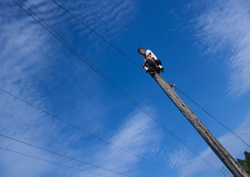 North Korean man working on telephone line pole, North Hamgyong Province, Chilbo Sea, North Korea