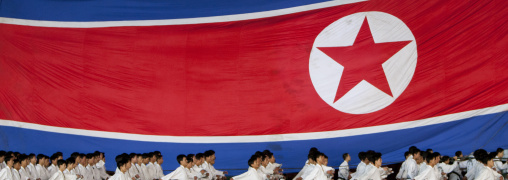 North Korean taekwondo team in front of a giant flag during the Arirang mass games in may day stadium, Pyongan Province, Pyongyang, North Korea