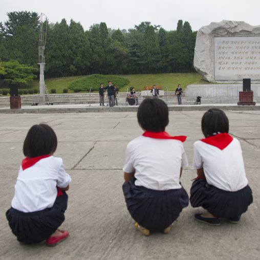 North Korean pioneers listening to a band playing music on national day in the street, Pyongan Province, Pyongyang, North Korea