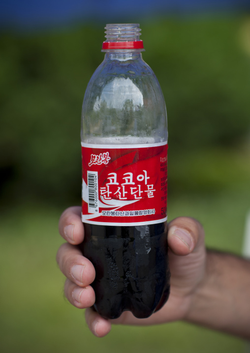 Man holding a bottle of North Korean cola named cocoa soda, North Hwanghae Province, Pyongyang, North Korea