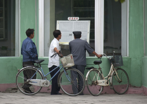 North Korean people reading the offical state newspaper in the street, North Hwanghae Province, Kaesong, North Korea