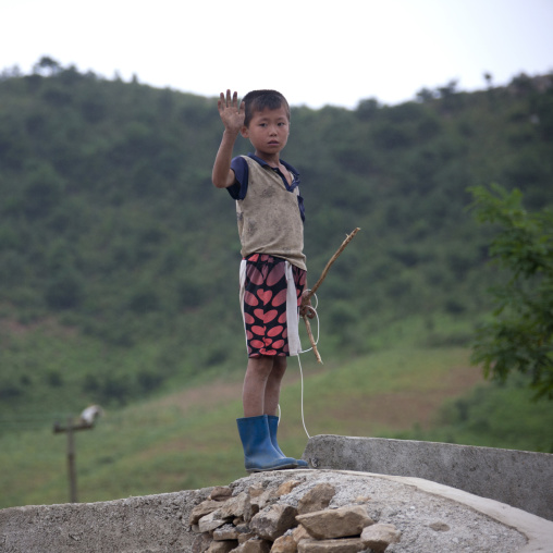 Grubby North Korean boy waving hand, North Hwanghae Province, Kaesong, North Korea