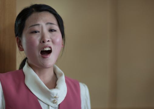 North Korean waitress in a restaurant singing for the tourists, Pyongan Province, Pyongyang, North Korea