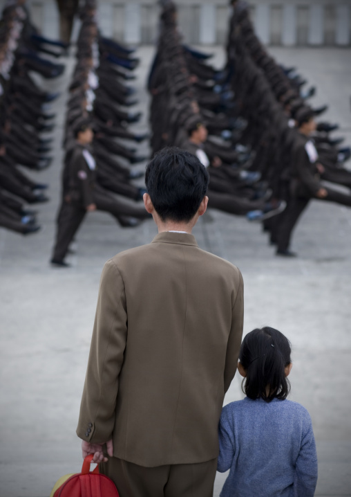 Father and daughter watching North Korean army parade on Kim il Sung square, Pyongan Province, Pyongyang, North Korea