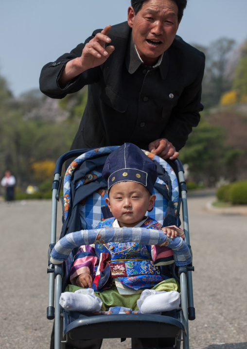 Portrait of a North Korean father with his one year old son in a baby-buggy
, Pyongan Province, Pyongyang, North Korea