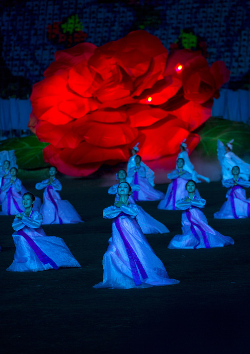 North Korean women dancing in front of a giant Kimilsungia flower during the Arirang mass games in may day stadium, Pyongan Province, Pyongyang, North Korea