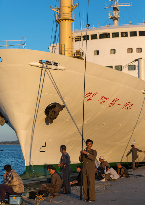 North Korean men fishing in front of a ship in the port, Kangwon Province, Wonsan, North Korea