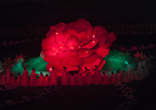 North Korean women dancing in front of a giant Kimilsungia flower during the Arirang mass games in may day stadium, Pyongan Province, Pyongyang, North Korea