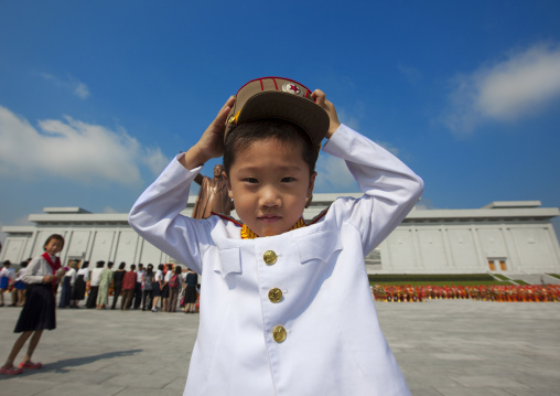 North Korean boy in army uniform putting his kepi in Grand monument of Mansu hill, Pyongan Province, Pyongyang, North Korea