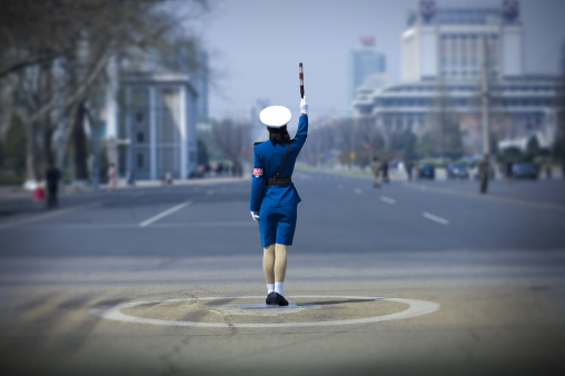 North Korean traffic security officer in blue uniform in the street, Pyongan Province, Pyongyang, North Korea