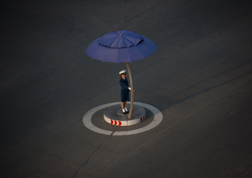 North Korean traffic security officer in blue uniform in the street, Pyongan Province, Pyongyang, North Korea