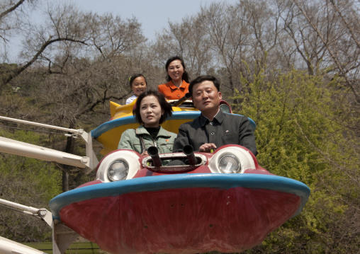 North Korean people having fun on a flying saucer attraction in Taesongsan funfair, Pyongan Province, Pyongyang, North Korea