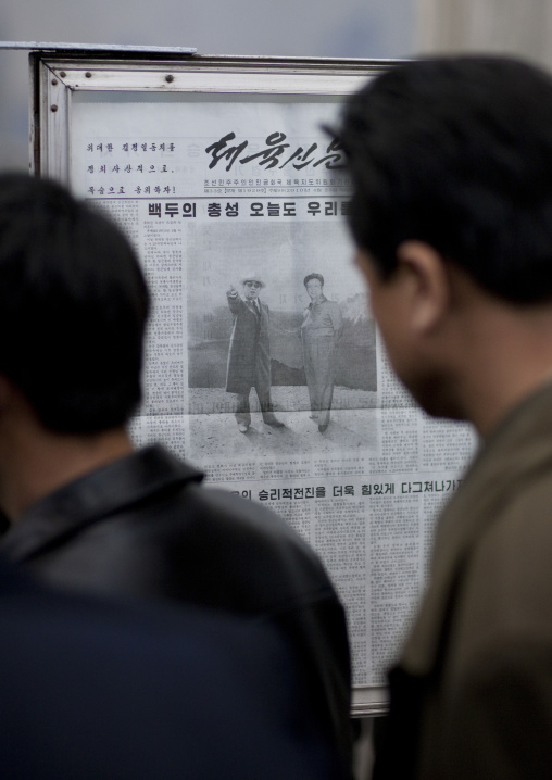 North Korean people reading the offical state newspaper in a subway station, Pyongan Province, Pyongyang, North Korea