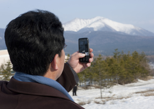 North Korean man taking picture of mount Paektu with his mobile phone
, Ryanggang Province, Samjiyon, North Korea