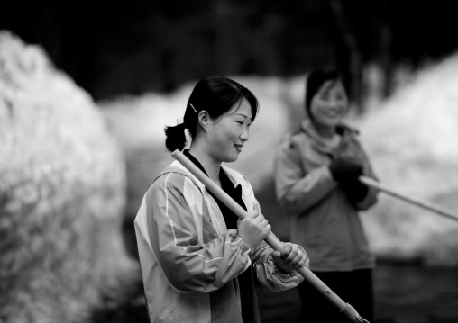 Young North Korean women removing snow at Kim Jong il's native home, Ryanggang Province, Samjiyon, North Korea