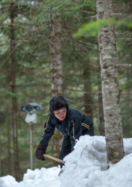 North Korean woman removing snow in the former secret camp of the Korean resistance against japanese in mount Paektu, Ryanggang Province, Samjiyon, North Korea