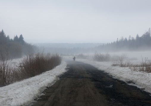 North Korean man pushing his bicycle on a snowy road, Ryanggang Province, Samjiyon, North Korea