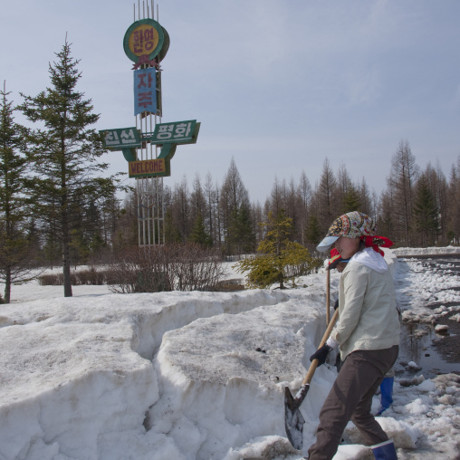 Girls clearing snow from the road in front of pegaebong hotel, Ryanggang Province, Samjiyon, North Korea