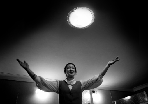 North Korean waitress singing in restaurant under halo light, Pyongan Province, Pyongyang, North Korea