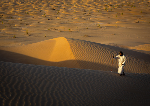 Omani man walking in the rub al khali desert, Dhofar Governorate, Rub al Khali, Oman