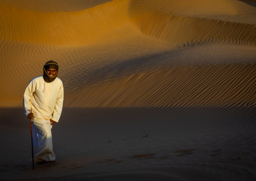 Omani man walking in the rub al khali desert, Dhofar Governorate, Rub al Khali, Oman