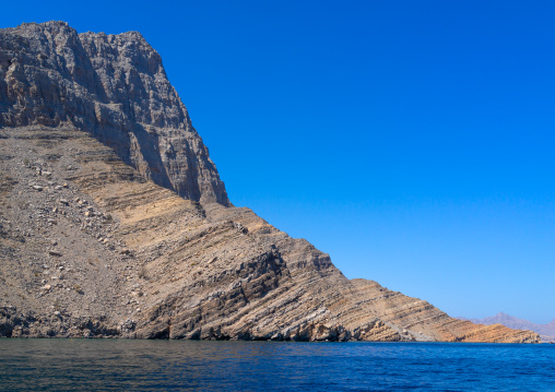 Dhow sailing in the fjords in front of mountains, Musandam Governorate, Khasab, Oman