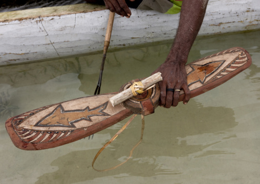 Man on a pirogue making a shark calling, New Ireland Province, Kavieng, Papua New Guinea